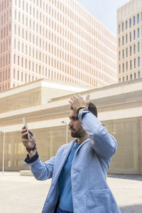 Young woman using mobile phone in city