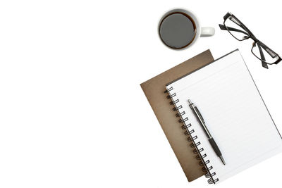 High angle view of pen and book against white background