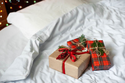 Boxes with christmas gifts on the bed . the bedroom is decorated with christmas lights.
