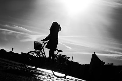 Silhouette woman standing by sea against sky during sunset