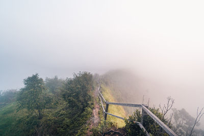 View of trail by railing against sky