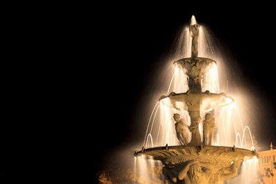 Low angle view of illuminated exhibition fountain at carlton gardens against sky