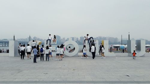 People on street in city against clear sky