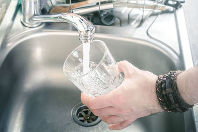 Midsection of woman holding glass with water