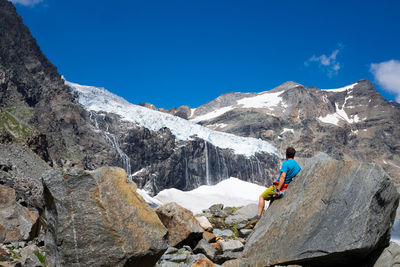 People skiing on snowcapped mountains against sky