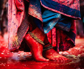 Red feet of woman standing at holi played in radha rani temple barsana, uttarpradesh, india