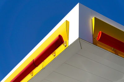 Low angle view of yellow building against blue sky