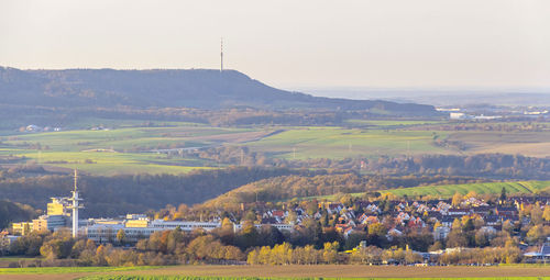 Scenic view of field by buildings against sky