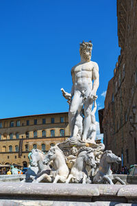 Low angle view of angel statue against clear blue sky
