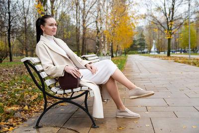 Side view of woman sitting in park