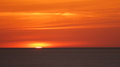 Scenic view of dramatic sky over sea during sunset