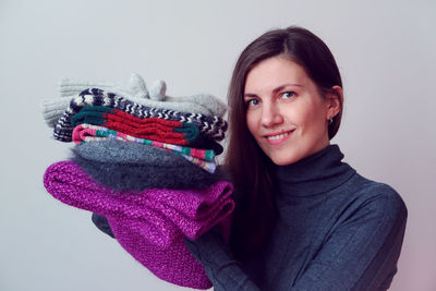 Portrait of smiling young woman against gray background