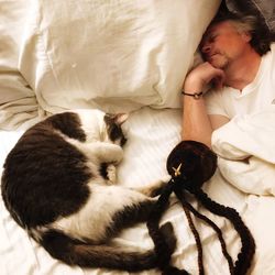 Man with cat sleeping on bed
