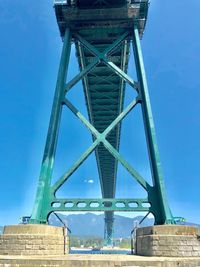 Low angle view of suspension bridge against blue sky