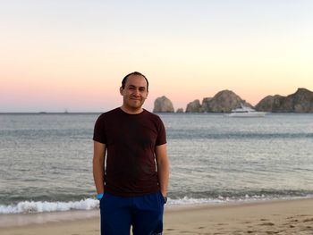 Portrait of man standing on beach during sunset