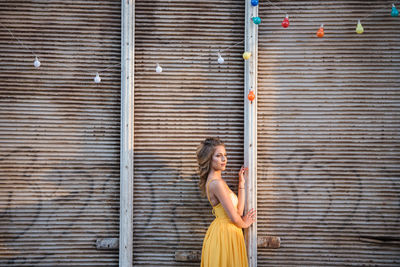 Side view of a woman against brick wall