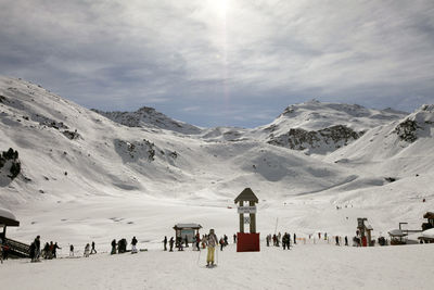 People on snow covered mountain against sky