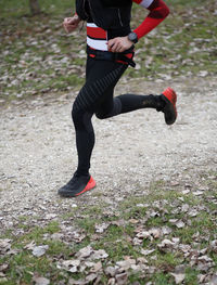 Low section of man running on field