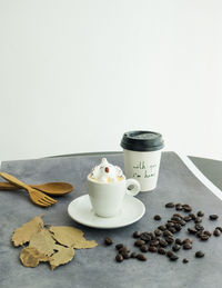 Coffee beans on table against white background