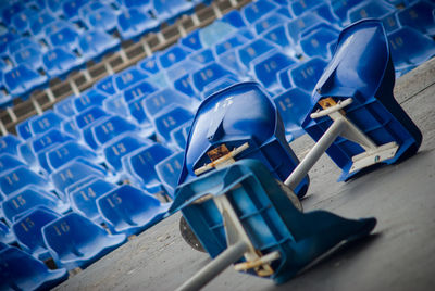Tilt shot of damaged fallen blue seats at stadium