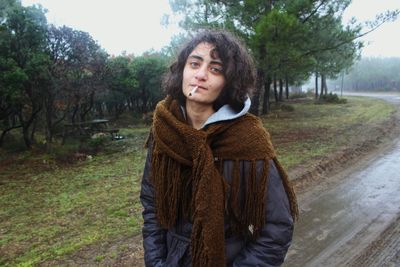 Portrait of young woman looking away while standing on land