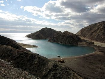 Scenic view of sea and mountains against sky