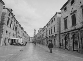 People in front of buildings against sky