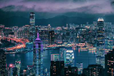 Illuminated buildings in city against sky at night