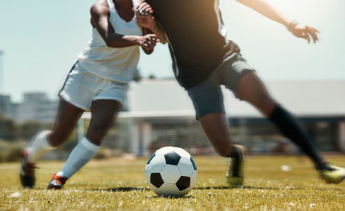 Low section of man playing soccer on field