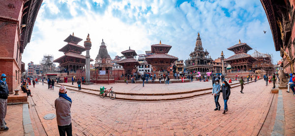 Panoramic view of crowd outside buildings against sky