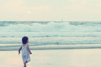 Rear view of girl at beach