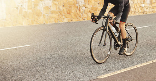 Low section of man riding bicycle on street