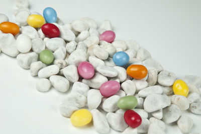 High angle view of multi colored candies on white background