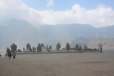 Scenic view of sea by mountains against sky