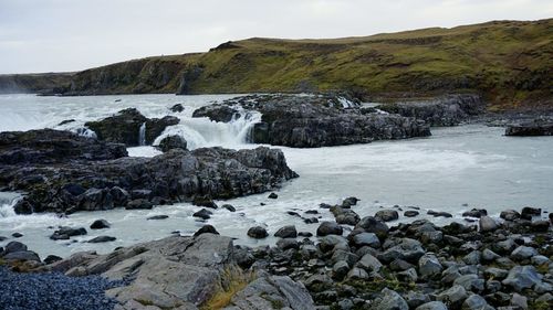 Scenic view of waterfall against sky