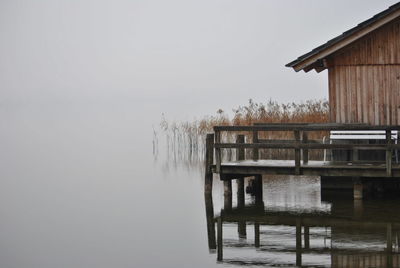 Stilt house on lake during foggy weather