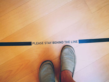 Low section of man standing on hardwood floor