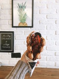 Woman holding smart phone against wall