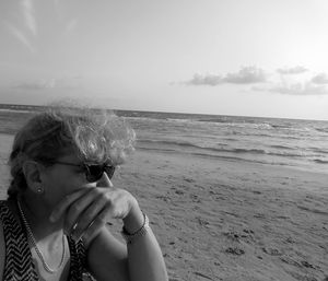 Woman enjoying at beach against sky