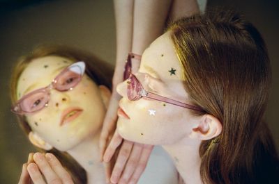 Close-up of reflection of woman with star shapes in mirror