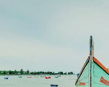 Boat moored on beach against sky