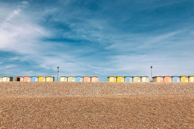 Beach huts on shore against sky