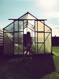 Side view of girl walking outside greenhouse