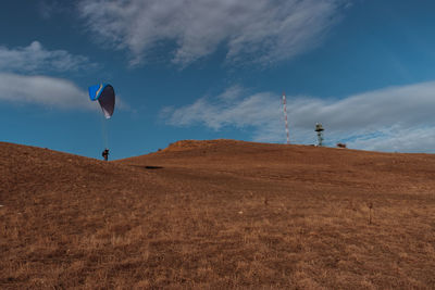 Low angle view of kite on land against sky