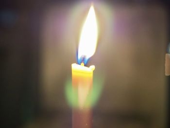 Close-up of lit candle in the dark