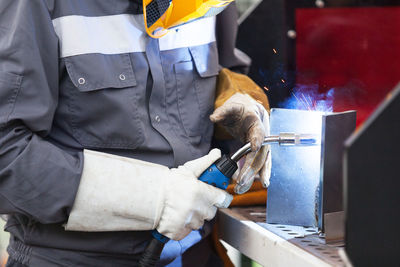 Midsection of manual worker working in factory