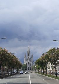 Road passing through city against sky