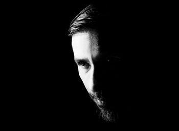 Portrait of man against black background