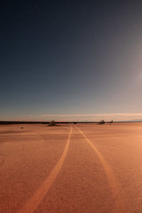 Scenic view of beach against clear sky at sunset