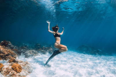 Rear view of woman swimming in sea